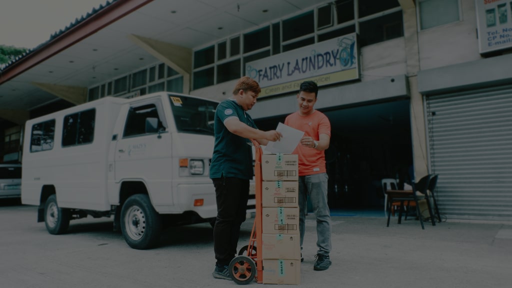 Mazy's staff delivering P&G laundry supplies to a laundry shop